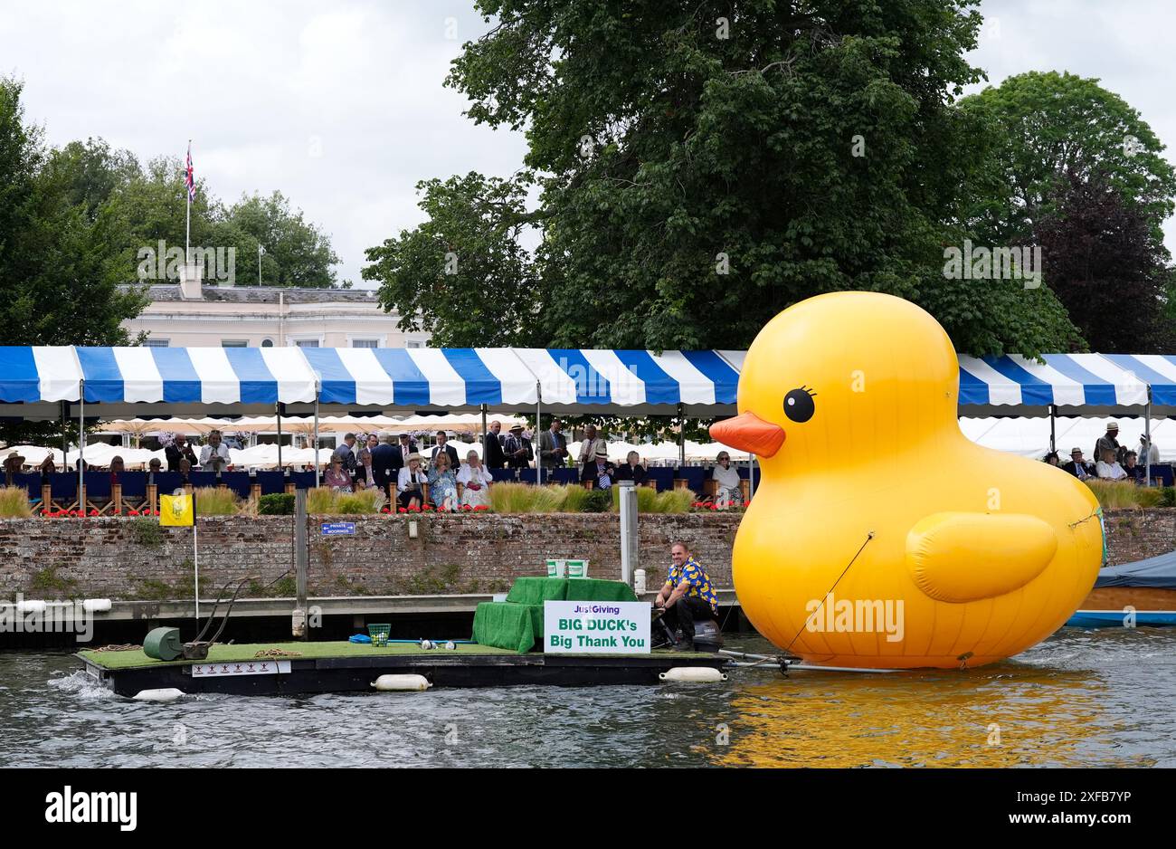 A large inflatable rubber duck is towed along the river Thames on the