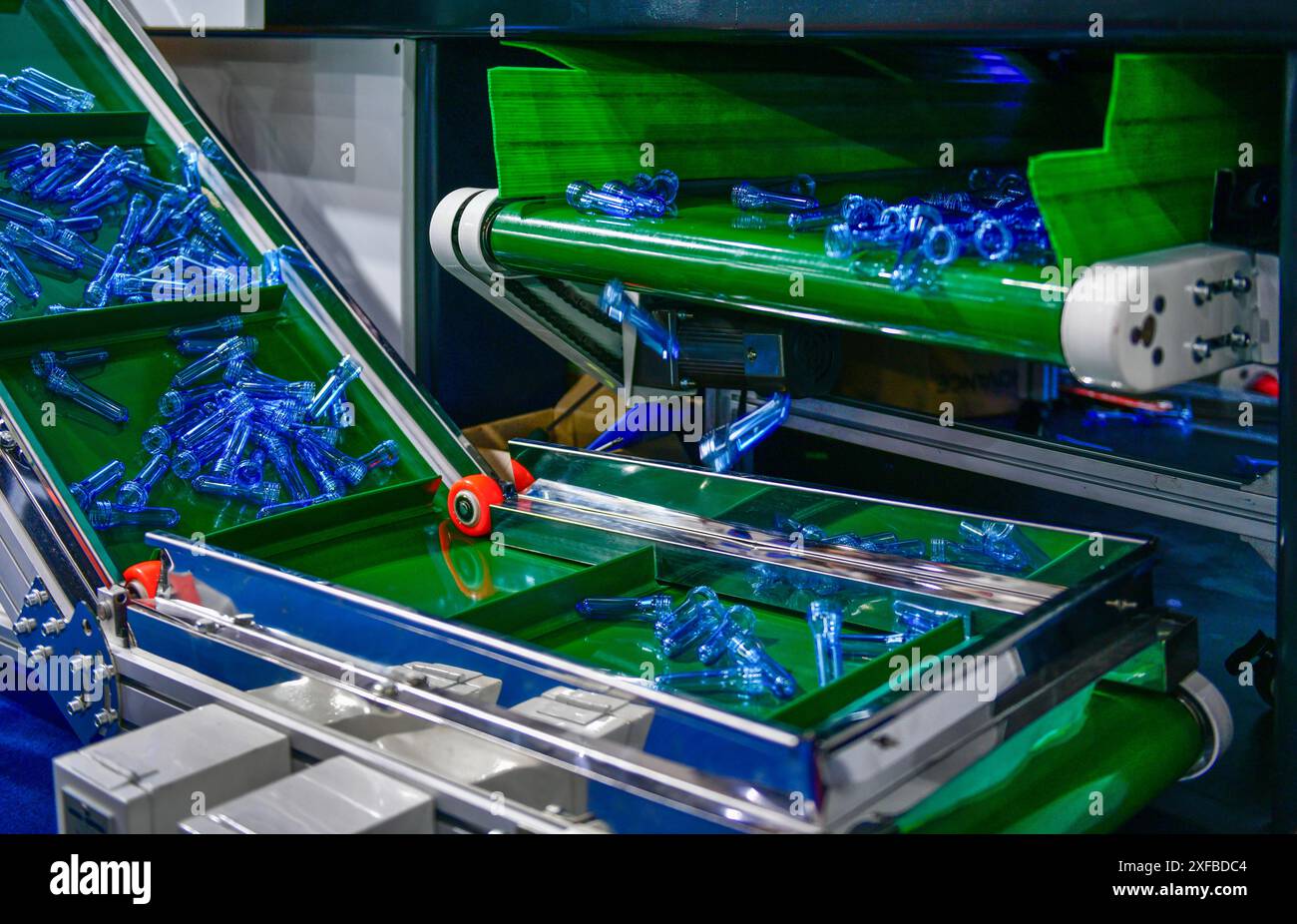 Blue Plastic bottles in production line at manufacturing PET perform, before bottles blowing in blowing machine at drink water factory. Stock Photo