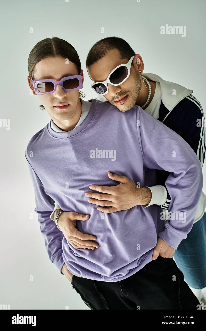 Two young men in purple shirts and sunglasses posing together Stock ...