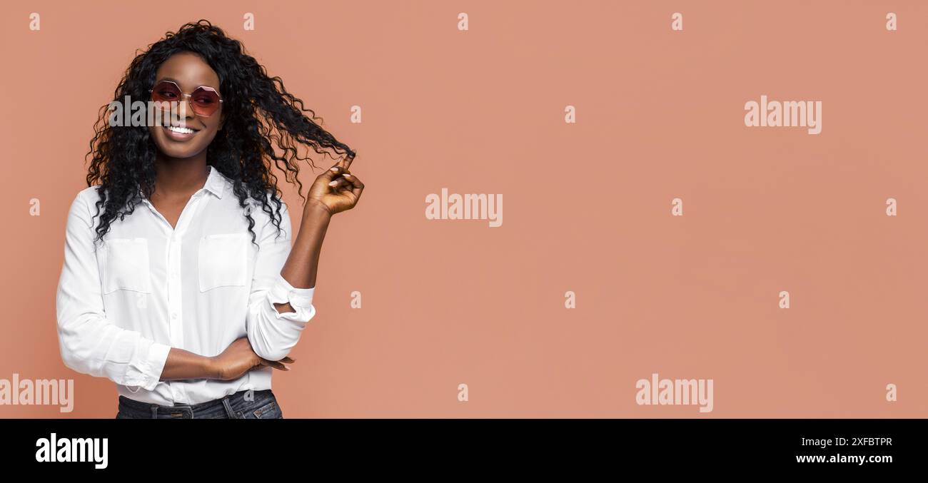 Woman With Long Curly Hair Wearing Sunglasses and White Shirt Stock Photo