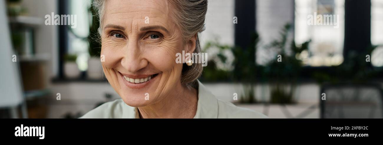 A mature woman with gray hair smiles warmly at the camera Stock Photo ...