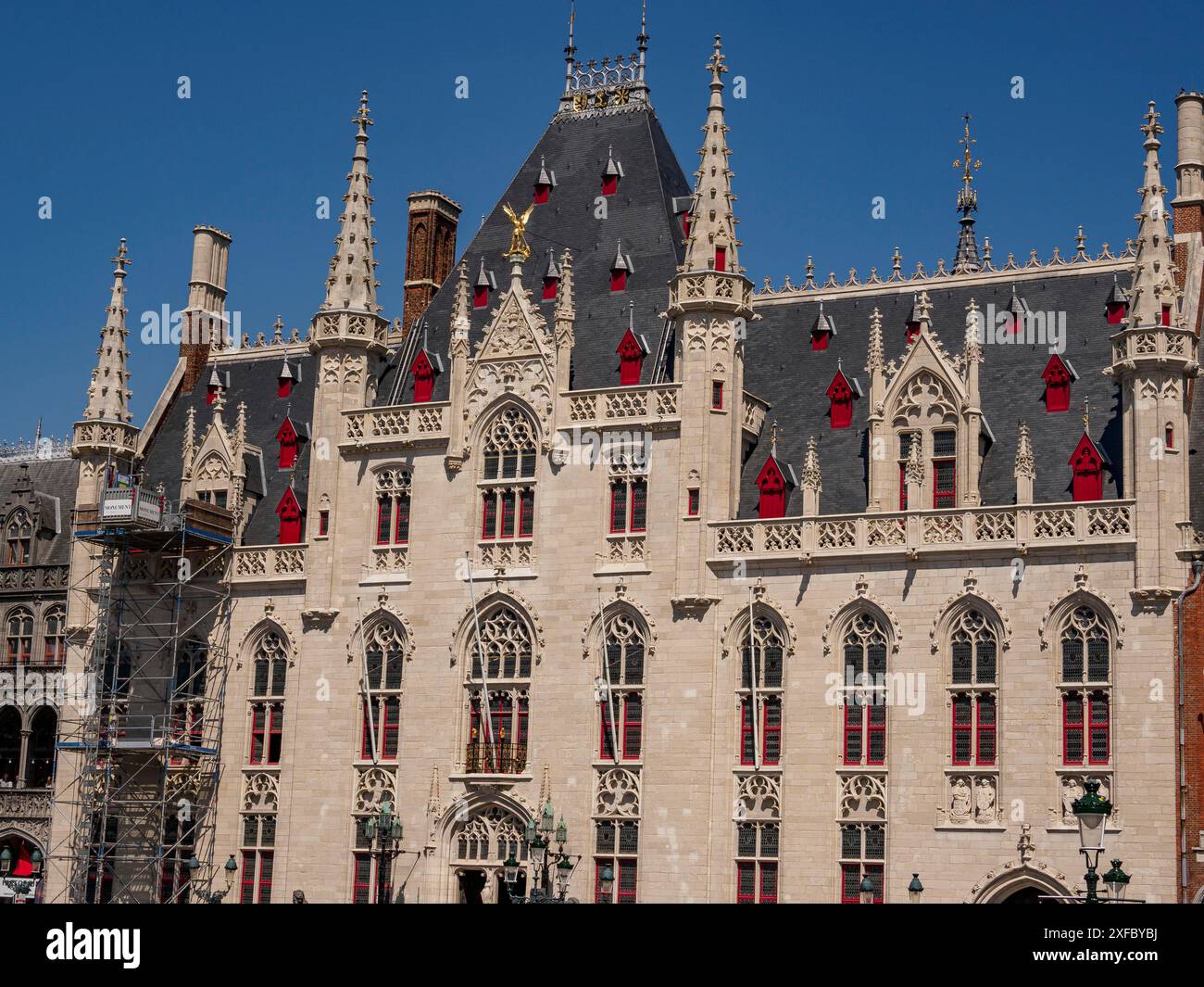 A restored Gothic building with many windows and towers under a clear ...