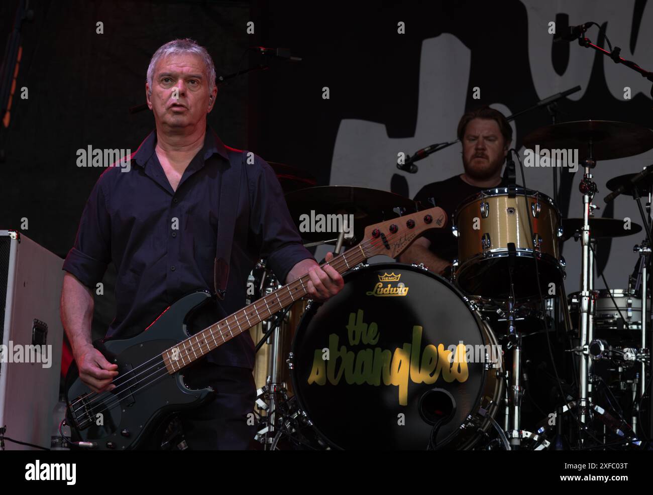 Guildford / UK - Jun 29 2024: Original band member Jean-Jacques Burnel performs with The Stranglers at Guilfest music festival, Guildford, Surrey, UK. Stock Photo