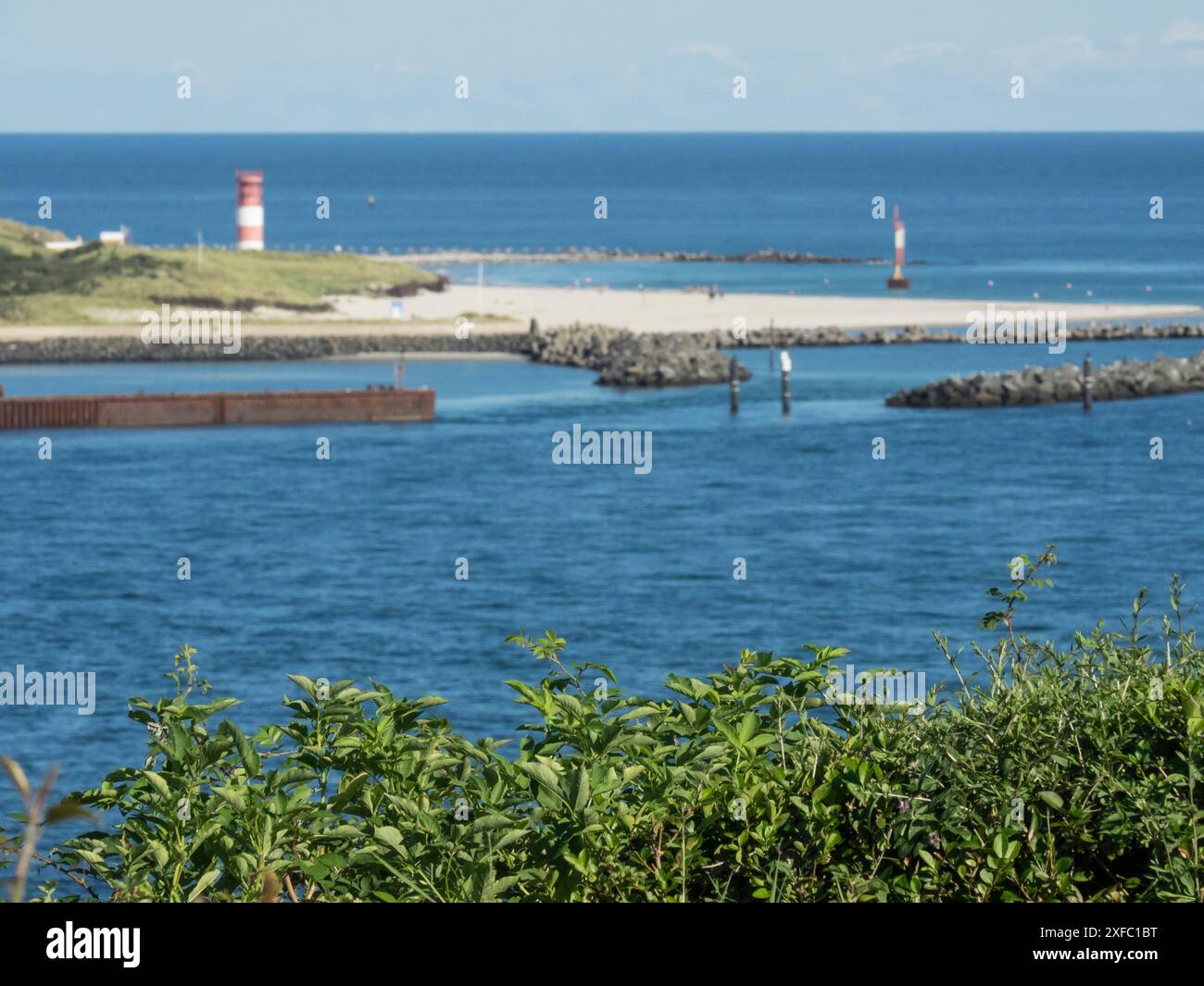 A view of a harbour with lighthouses and buoys floating in the calm blue waters of the sea, helgoland, north sea, germany Stock Photo