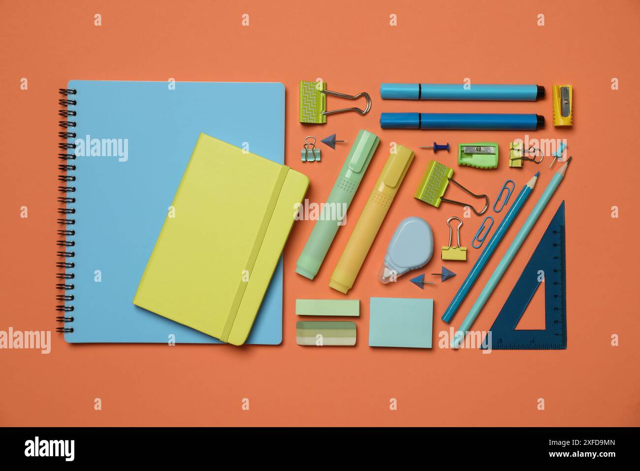 Flat lay composition with notebooks and different stationery on orange background Stock Photo