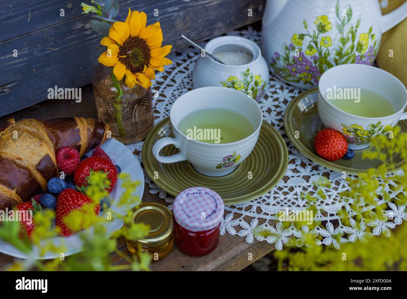 Morning summer tea with flowers and fruits on the veranda in the ...