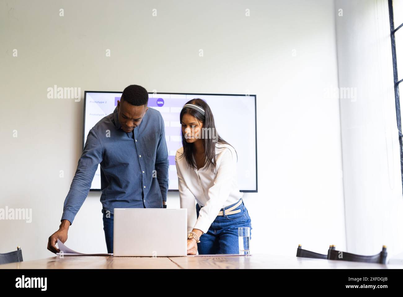Collaborating on project, colleagues reviewing documents and using laptop in office Stock Photo