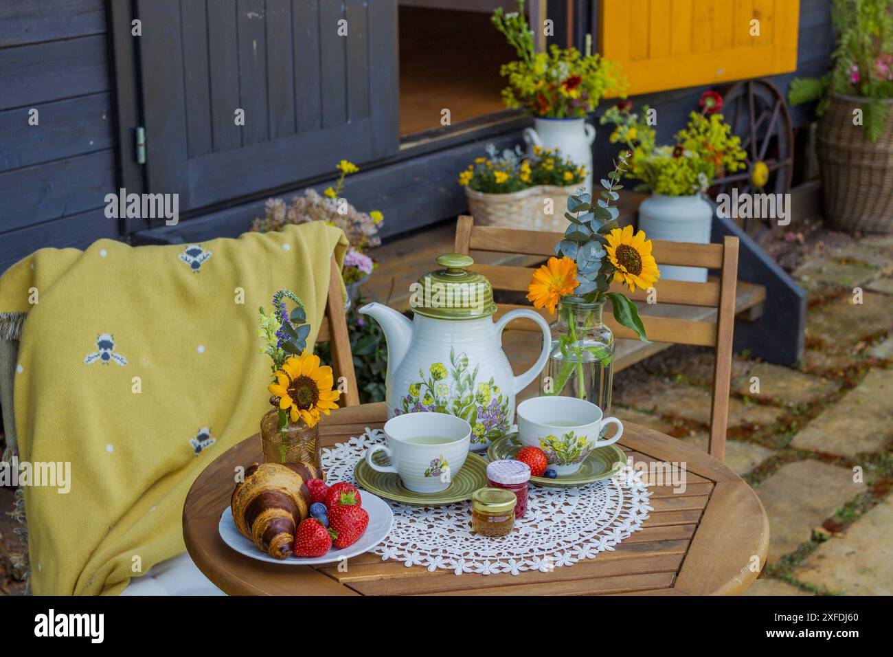 Morning summer tea with flowers and fruits on the veranda in the ...