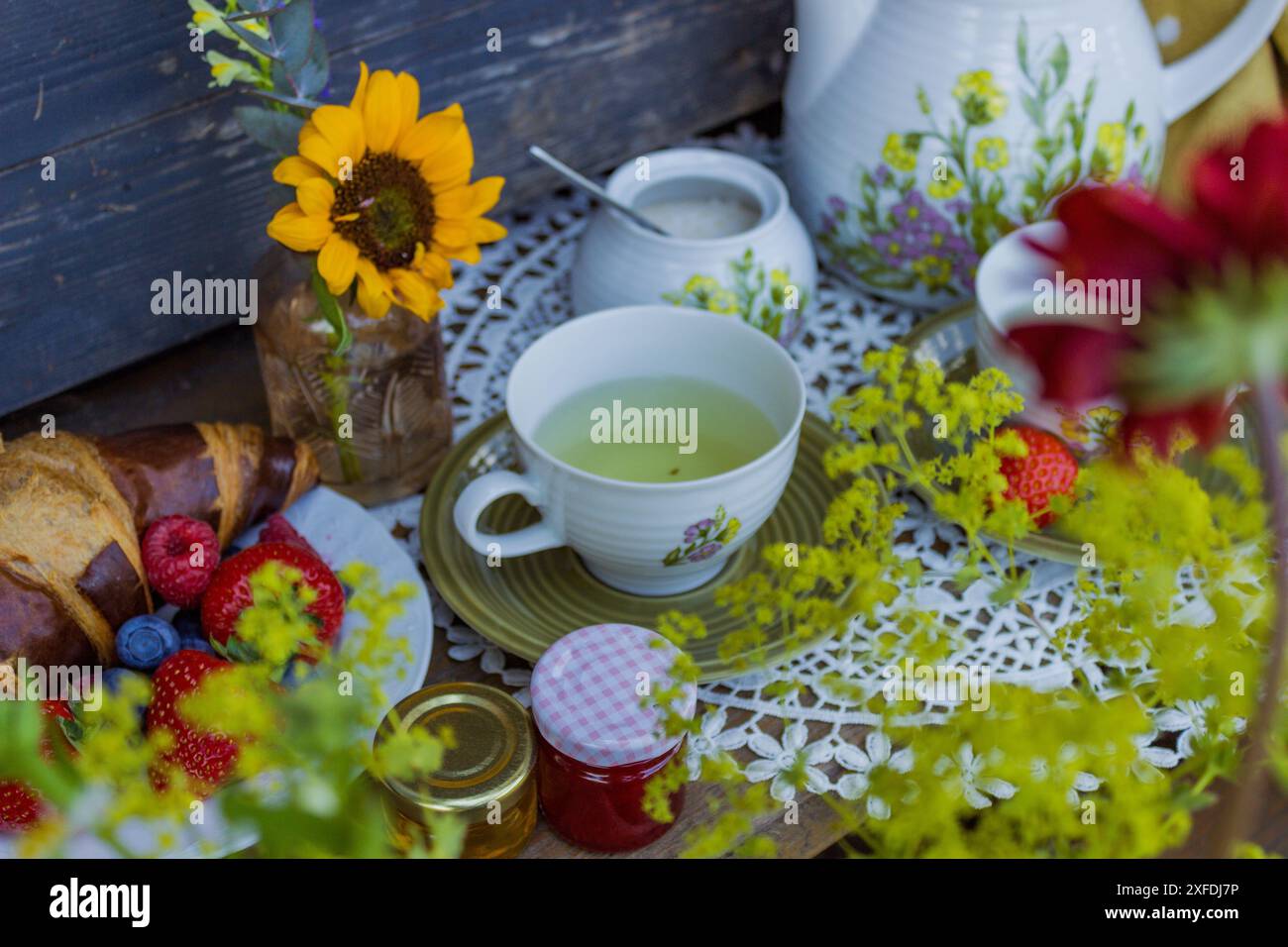 Morning summer tea with flowers and fruits on the veranda in the ...