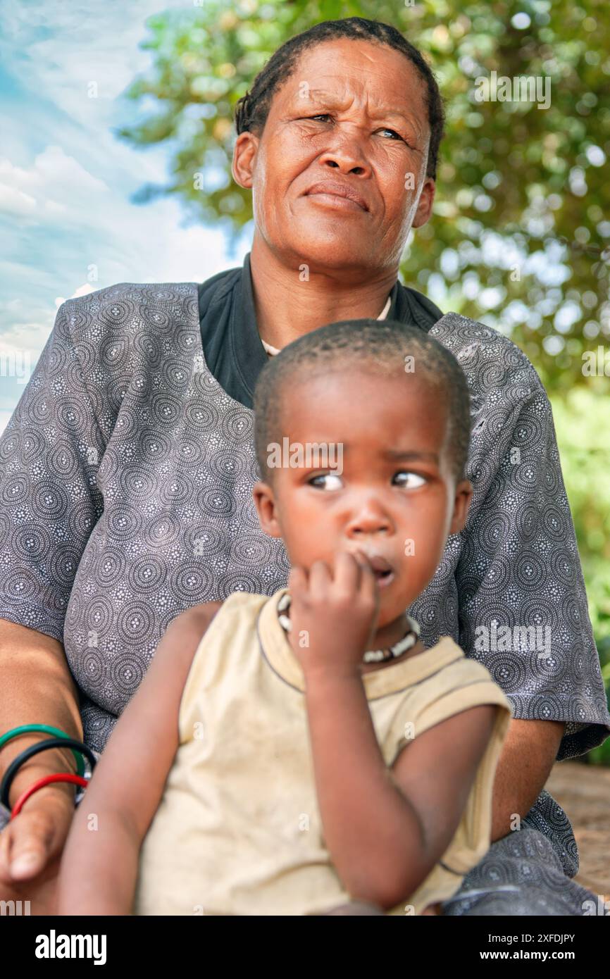 african child toddler in grandmother arms, village people Stock Photo