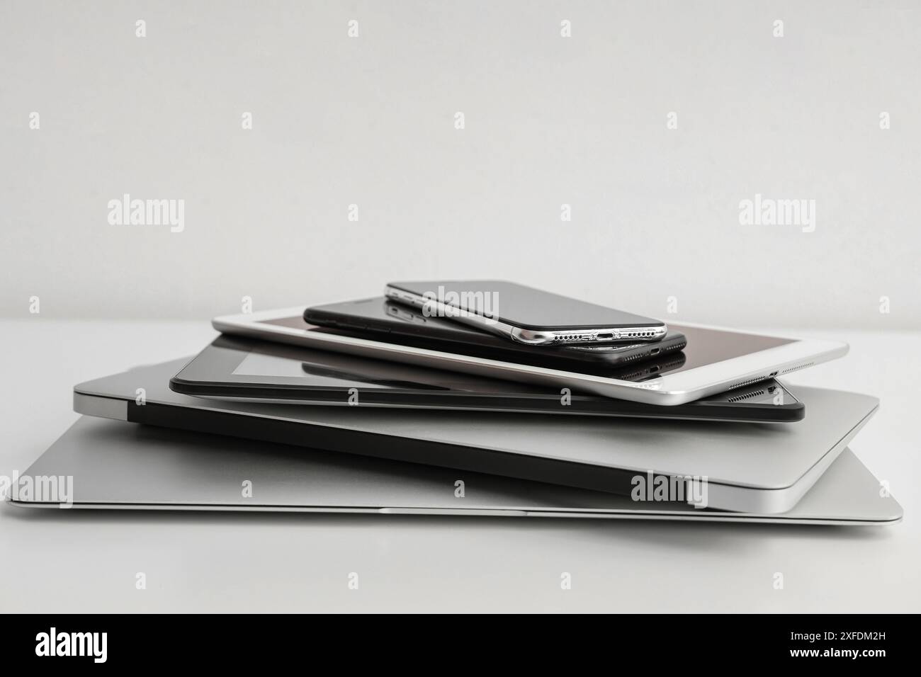 Stack of different modern gadgets on light background Stock Photo