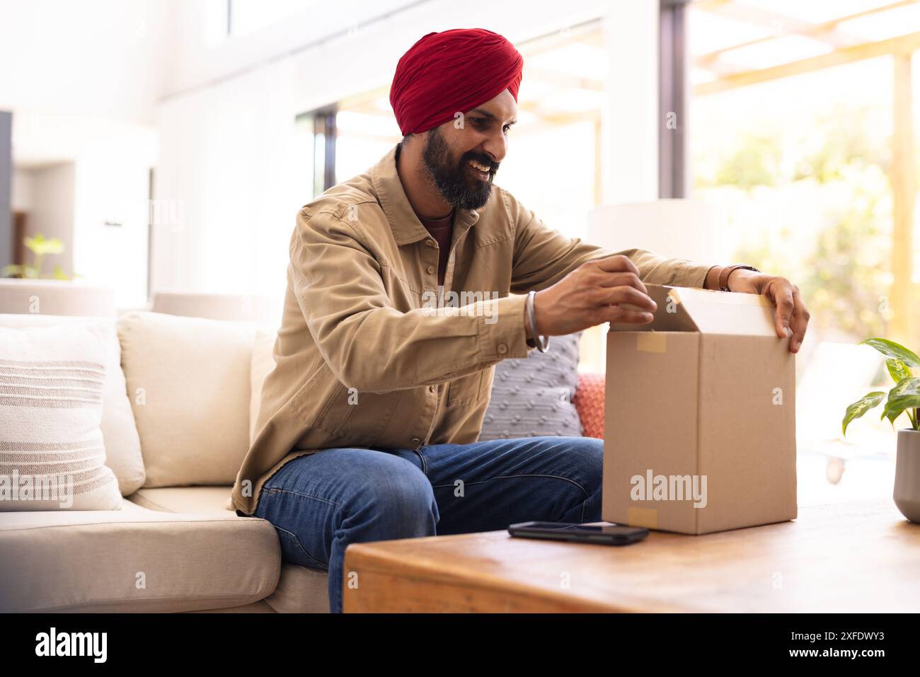 Man sitting couch smiling hi-res stock photography and images - Alamy