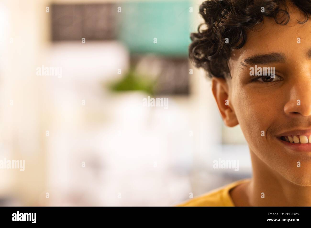 Smiling teenage boy focusing on classroom activities in high school, copy space Stock Photo