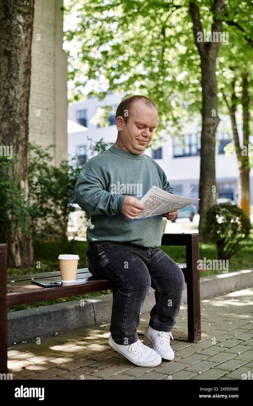 A man with inclusivity sits on a park bench reading a newspaper Stock ...
