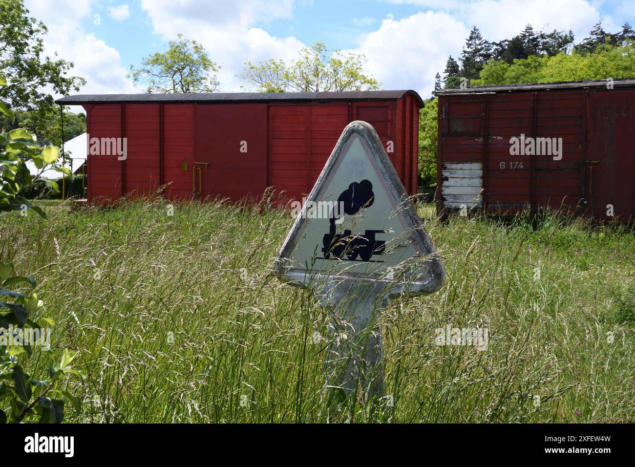 overgrown railway sign and old railway wagons, France, Brittany, Langueux Stock Photo