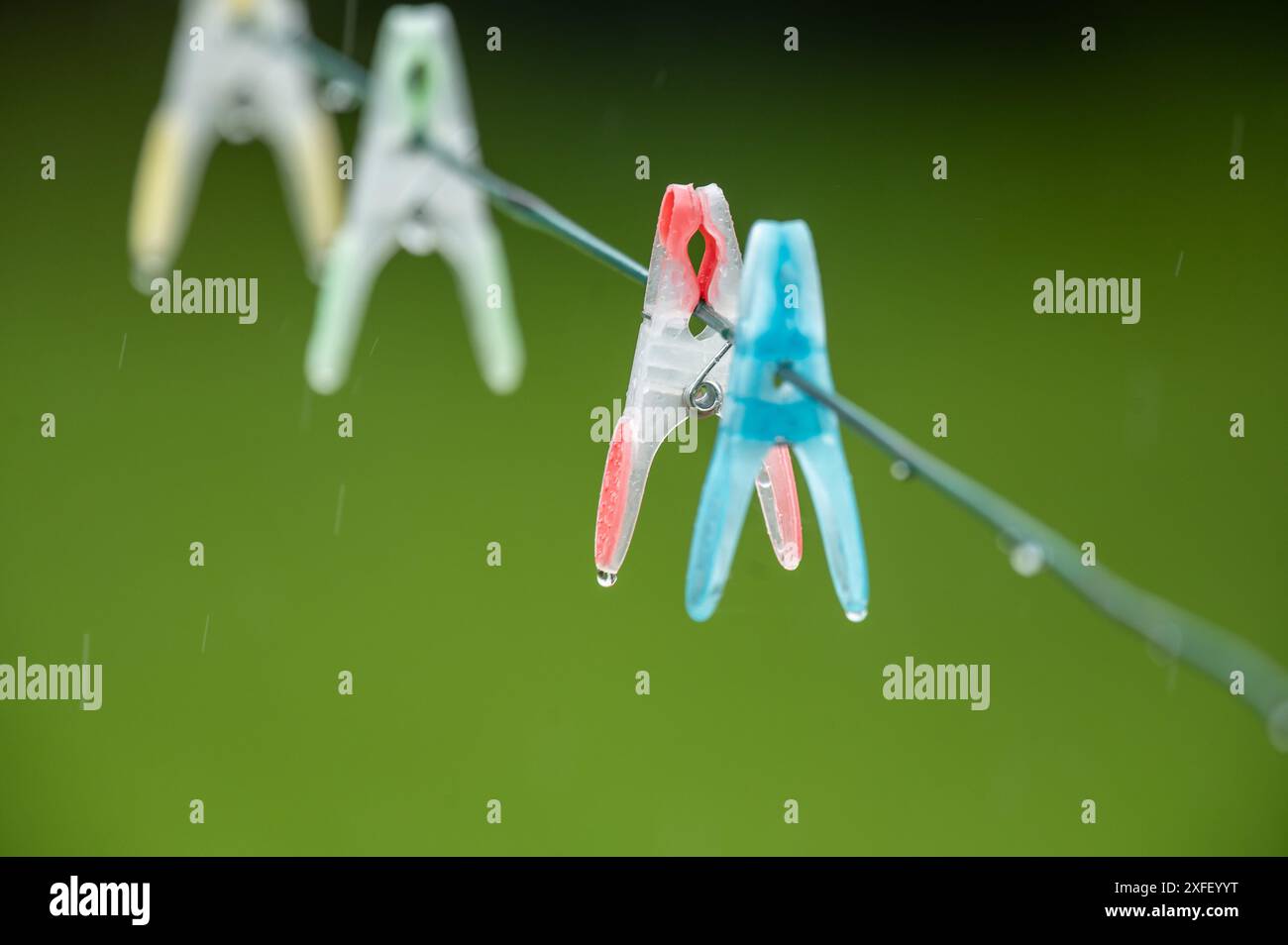 Rottweil, Germany. 03rd July, 2024. Raindrops hang from clothespins on