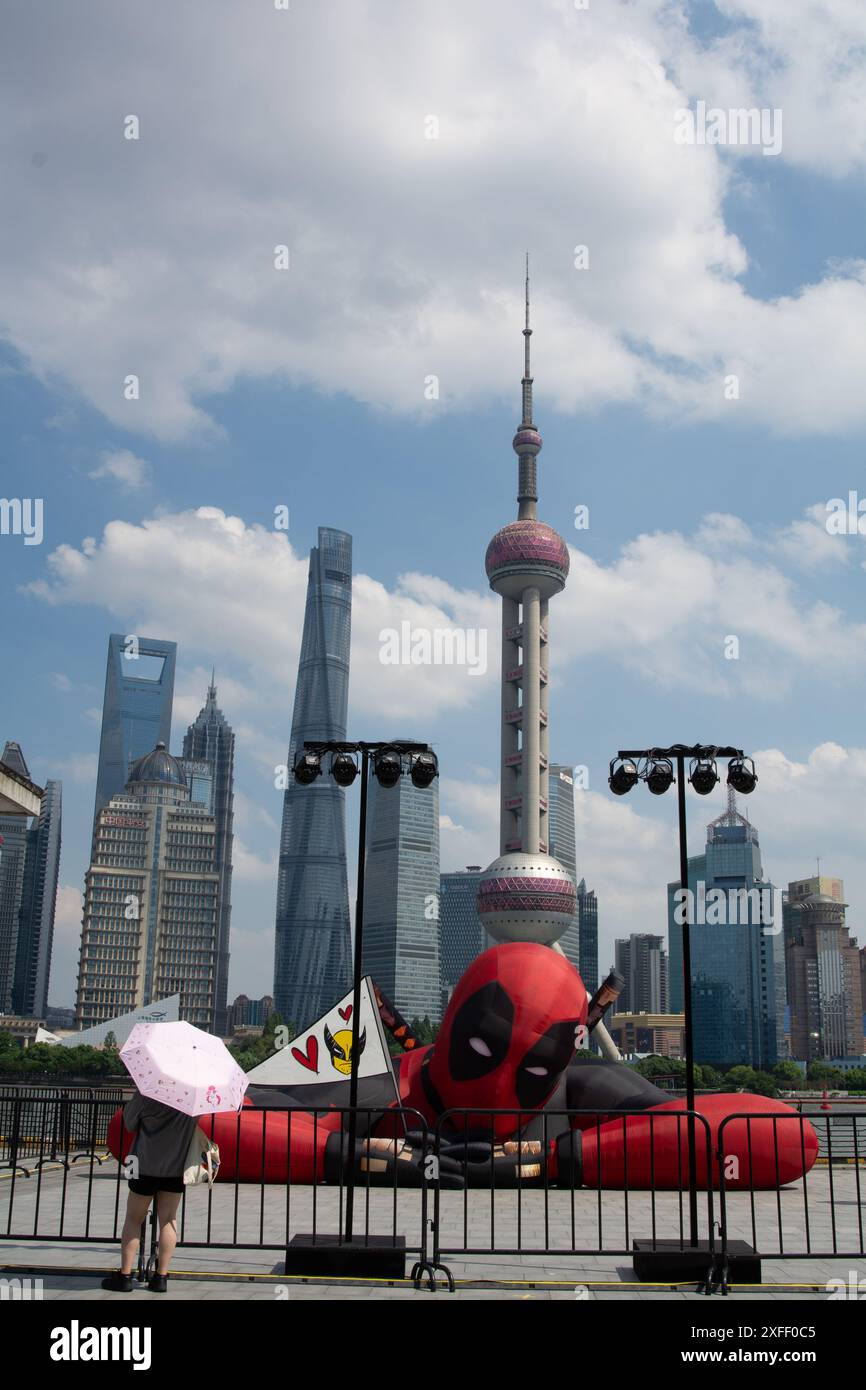 Shanghai, China. 03rd July, 2024. People are taking pictures with a large figure of an air balloon of Wolverine and Deadpool, which is resting at North Bund in Shanghai, China, on July 3. The 2024 new movie is starting its press tour around the world. (Photo by Ying Tang/NurPhoto) Credit: NurPhoto SRL/Alamy Live News Stock Photo