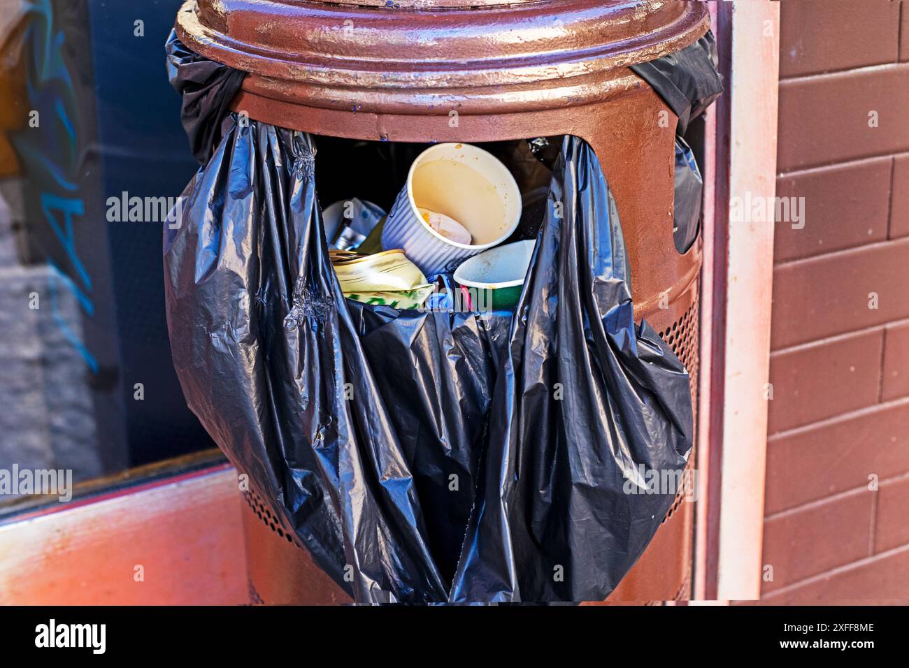 trash in a black trash bag on the street. Everyday waste Stock Photo