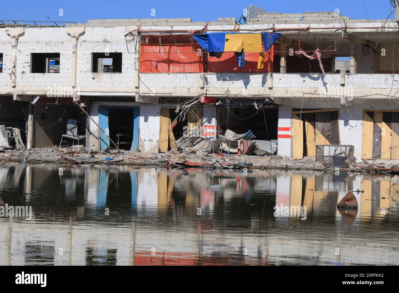 sewage-water-is-seen-in-the-middle-of-a-street-between-destroyed