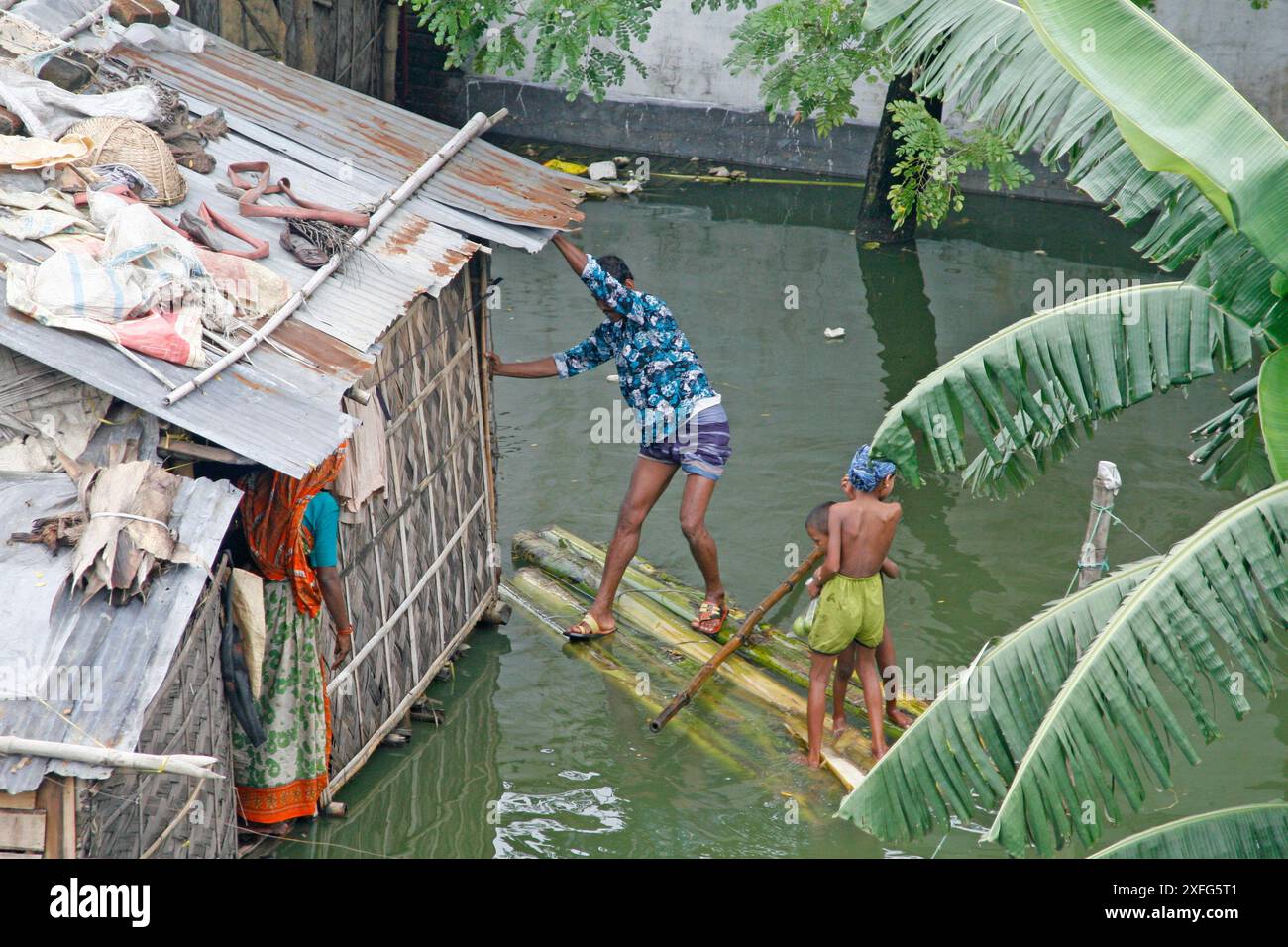 Slum dwellers of low-lying area at Adabar Friday use a raft as water ...