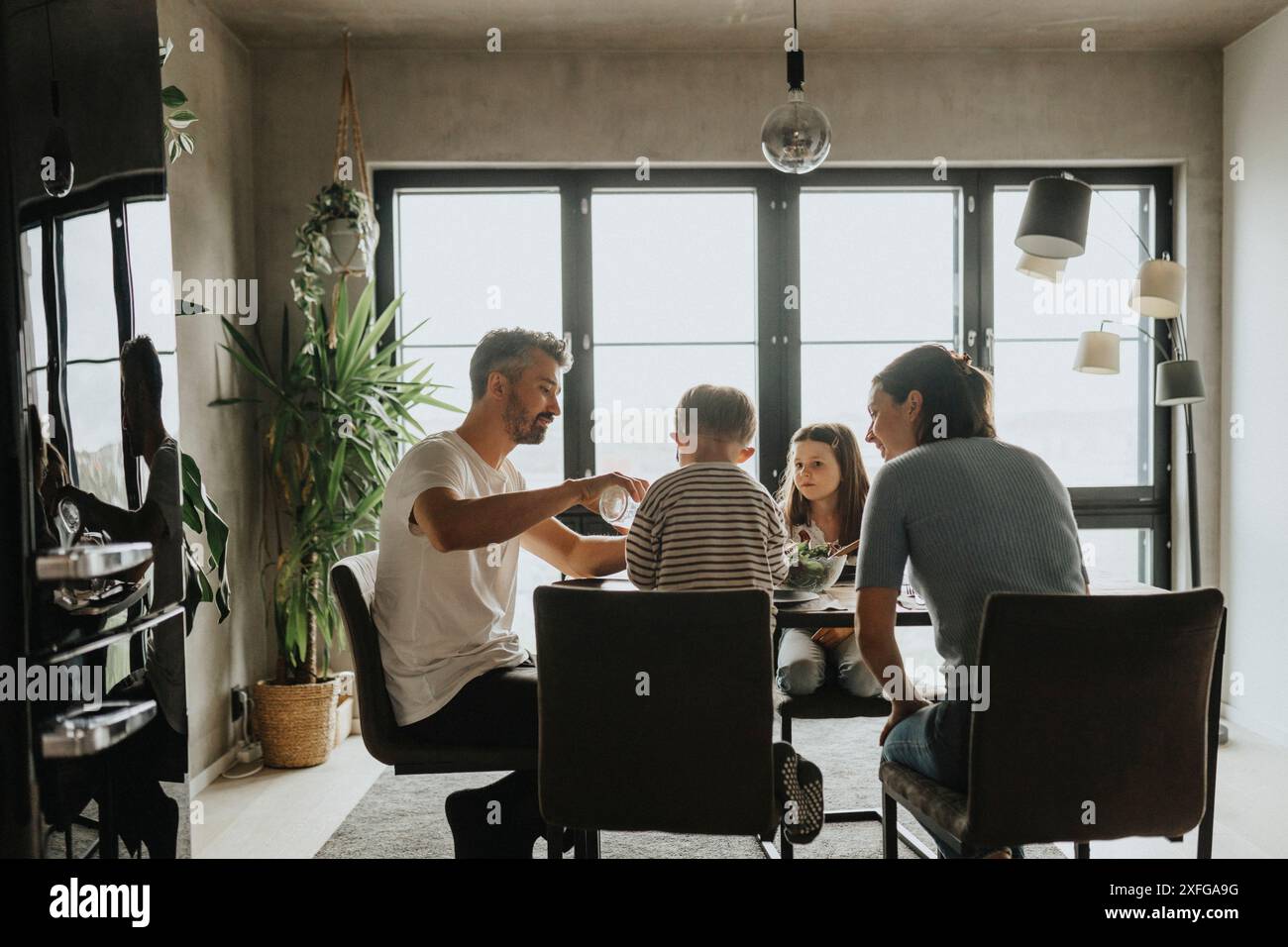 Family having lunch on dining table while sitting in living room at home Stock Photo