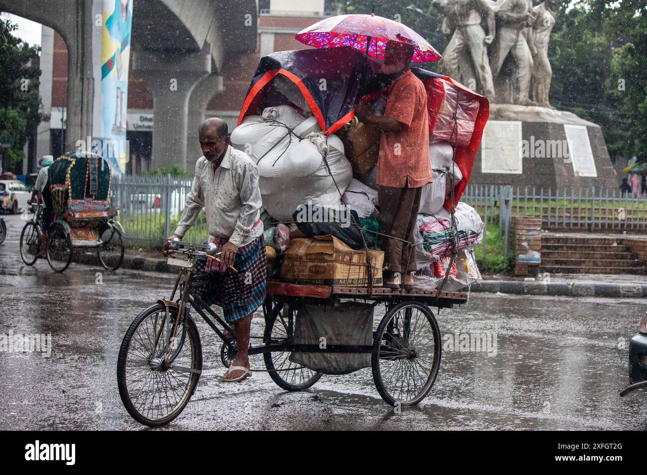 Hasan Reksha Dhaka, Bangladesh. 3rd July, 2024. A man is standing on a rickshaw-van ...