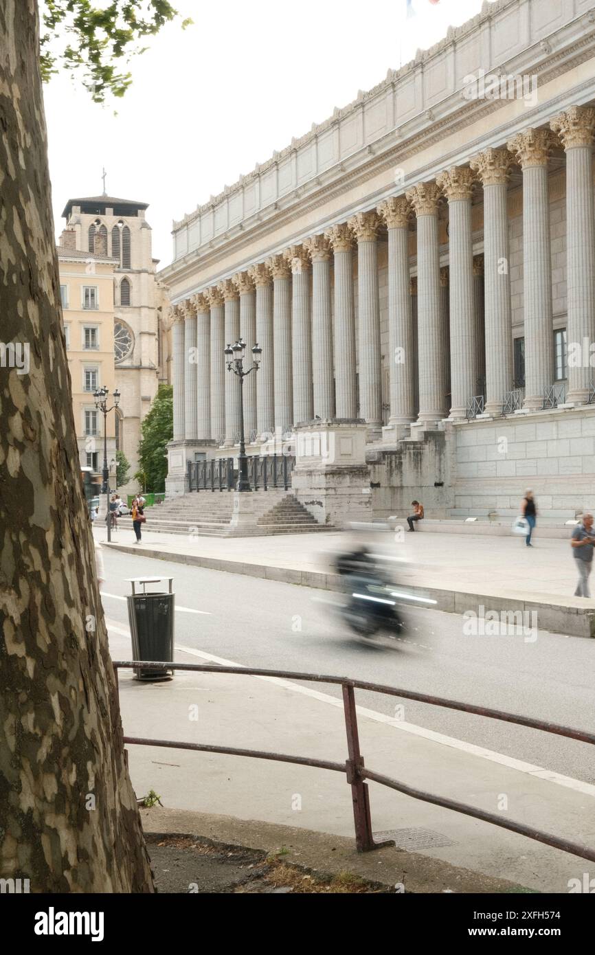 A bustling street scene in front of the Lyon Courthouse with its iconic ...