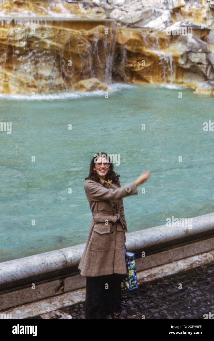 1970s, Young Woman Tossing a Coin into Trevi Fountain, Rome, Italy Stock Photo