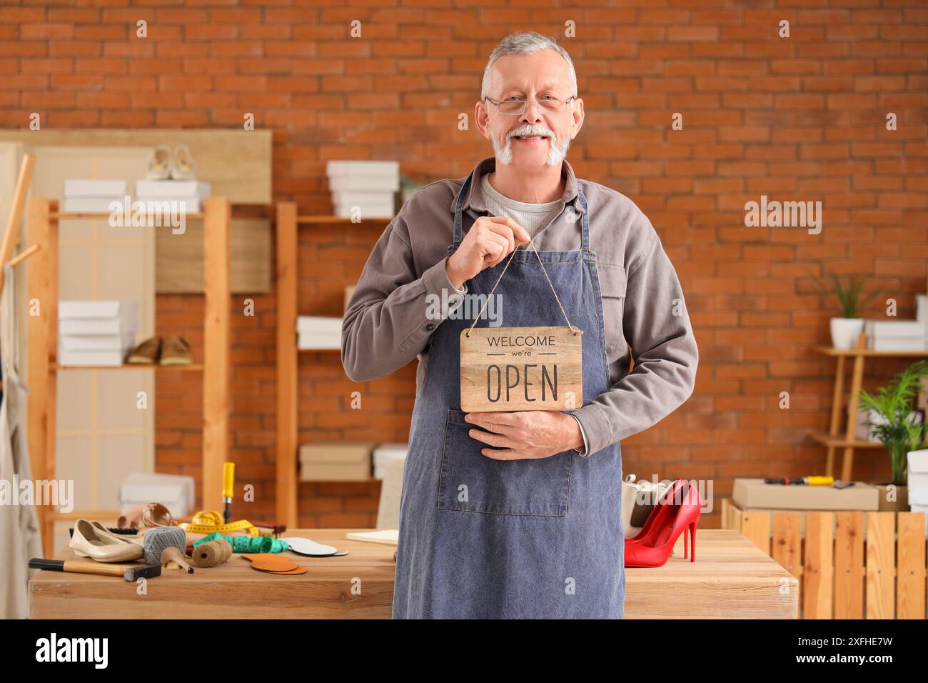 Shoemaker Open Sign Male shoemaker with OPEN sign in workshop Stock Photo - Alamy