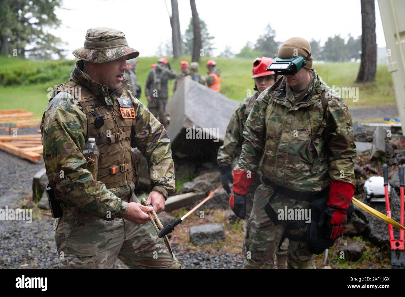 An Oregon National Guard search and rescue team lead educates Airmen on proper technique when handling a welding torch during a training exercise and evaluation for Oregon’s Chemical, Biological, Radiological, Nuclear and Explosives (CBRNE) Enhanced Force Package (CERFP) at Camp Rilea, Warrenton, Ore., on June 2, 2024. The exercise simulated natural and man-made disasters, allotting members an opportunity to practice search and rescue tactics. (U.S. Air National Guard photo by Staff Sgt. Nichole Sanchez) Stock Photo