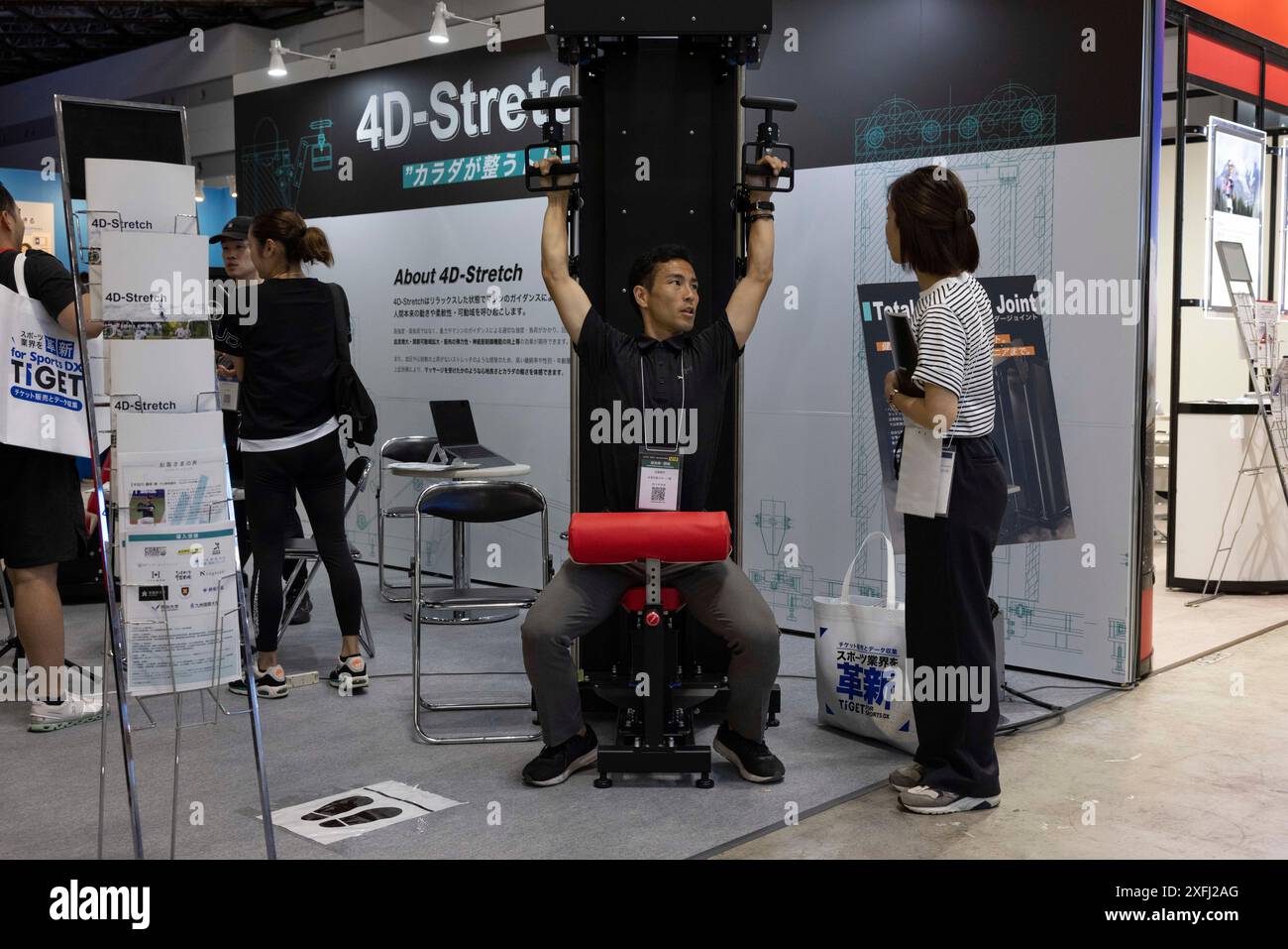 Tokyo, Japan. 03rd July, 2024. Visitor of 'Japan Sports Week' exhibition receives an explanation about a new lat pull down machine. Exercise and strength training are becoming more popular in Japan. New domestic and international exercise and health equipment companies are entering the Japanese market which grows every year. Credit: SOPA Images Limited/Alamy Live News Stock Photo