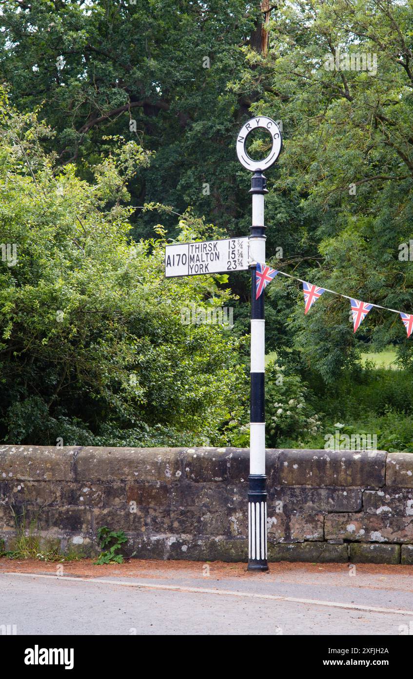 Traditional cast metal signpost on the A170 in Helmsley, Yorkshire ...