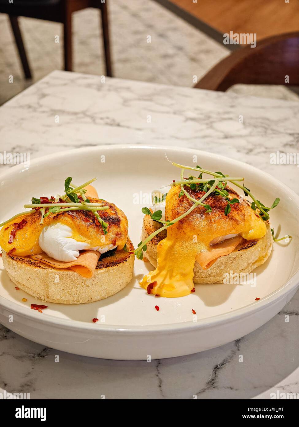 Eggs Benedict on white plate. Delicious breakfast set. Stock Photo