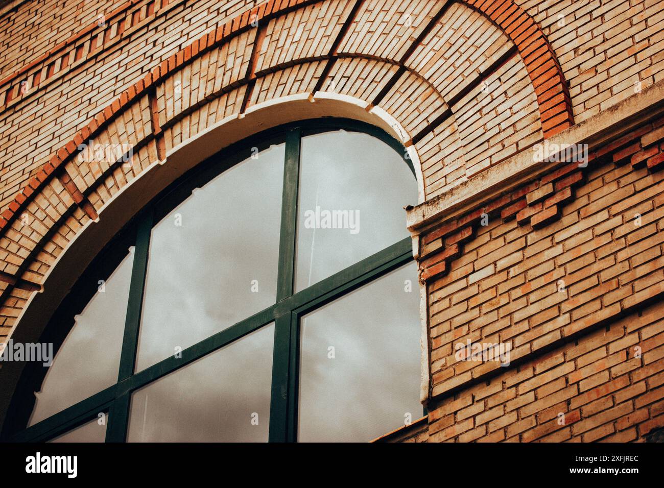 The side of an abandoned factory building with brick red wall and ...