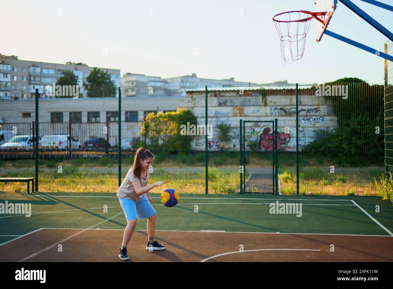 Yball Joyful young sport girl kid playing basketball on playground. Girl ...