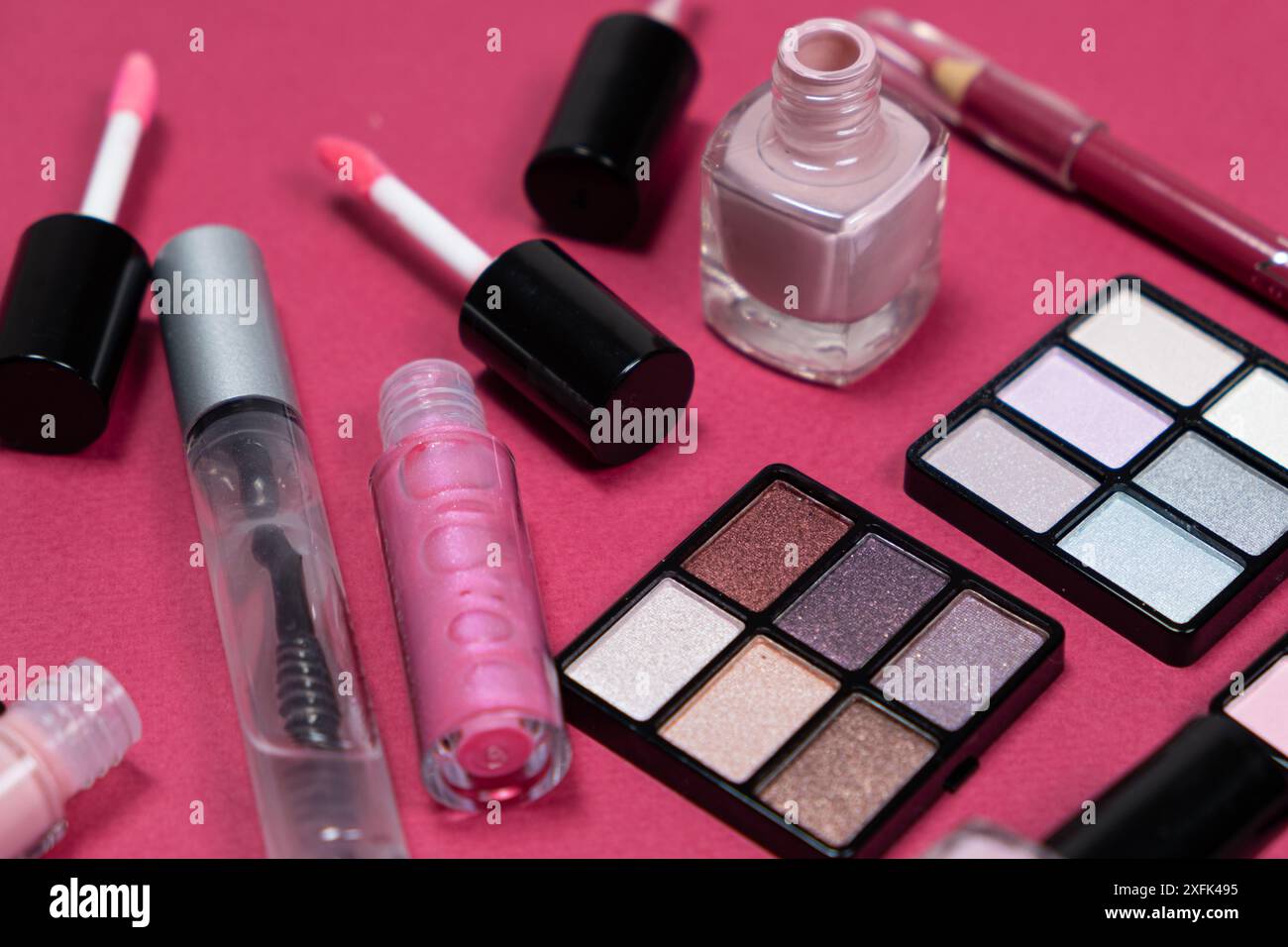 Various decorative cosmetics and brushes on a pink background. Stock Photo