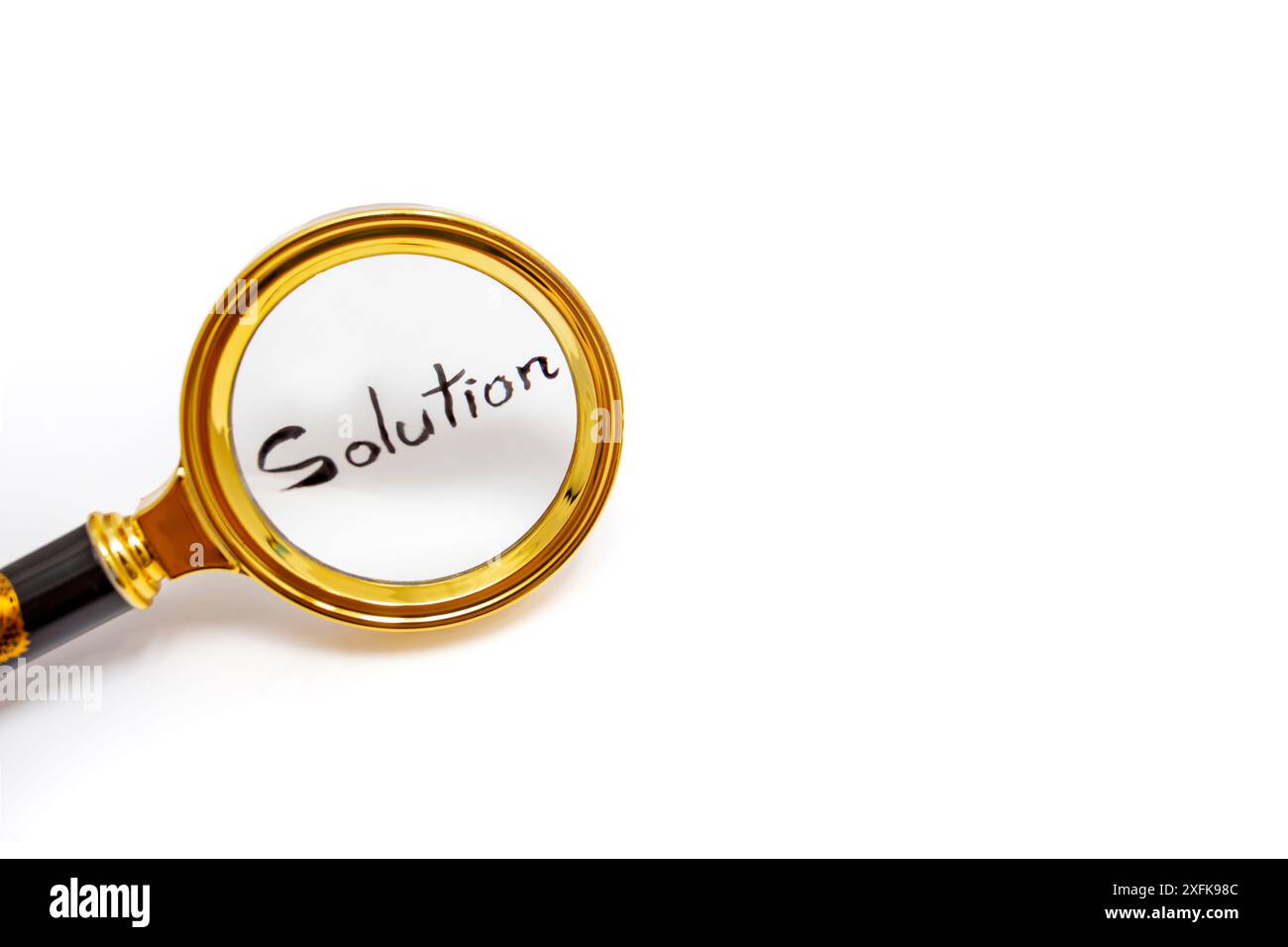 Solution word hand written with black ink, under a golden magnifying glass, isolated on white Stock Photo