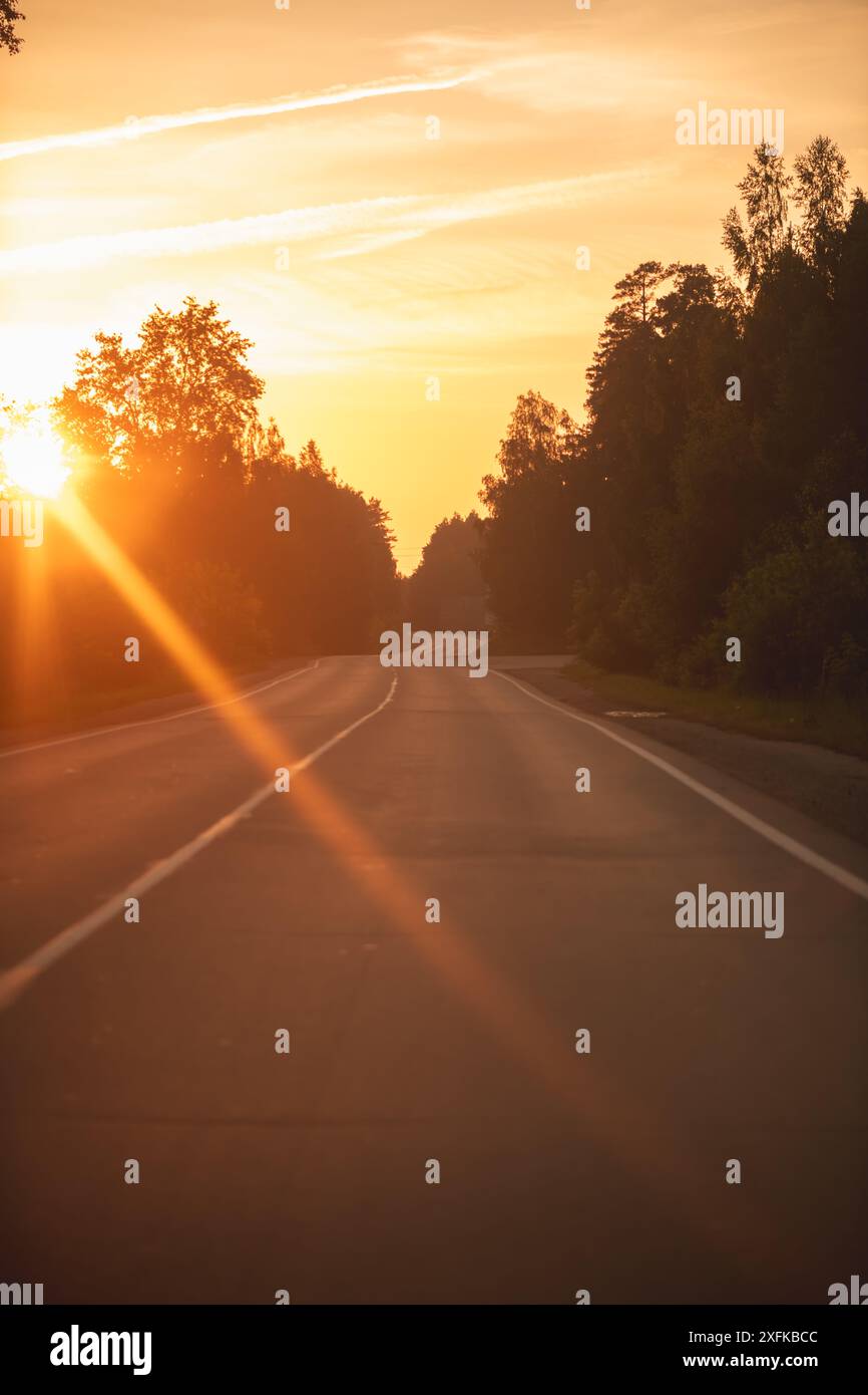 The asphalt road goes into the distance On the Sunset Stock Photo - Alamy