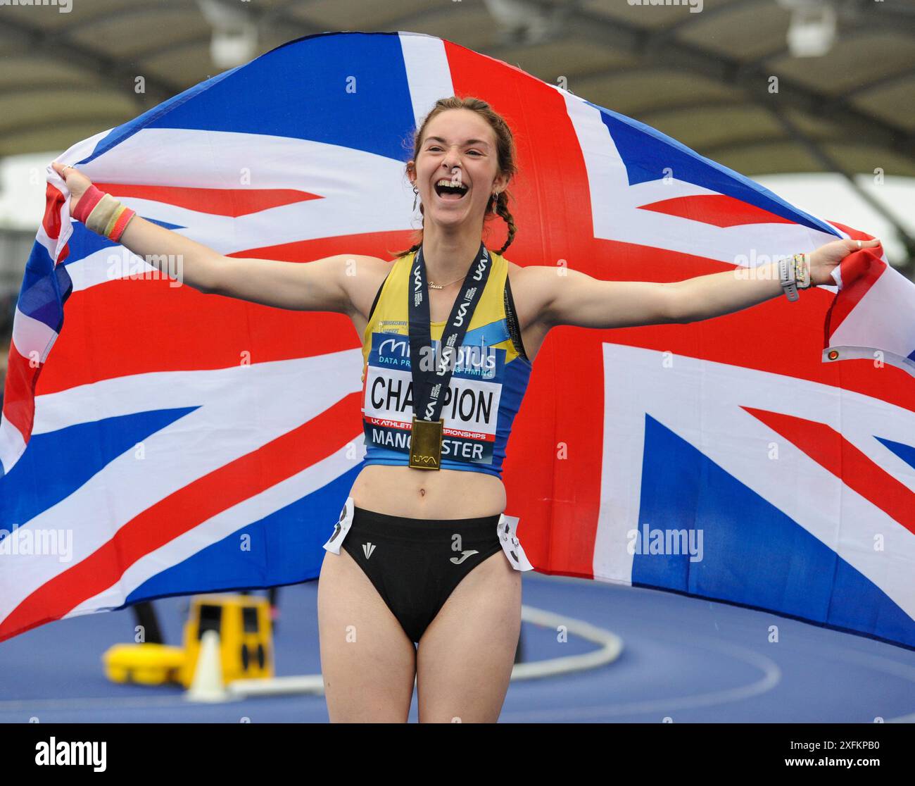 A lauging Gracie Griffiths holds up the Union Jack after winning 5000m ...