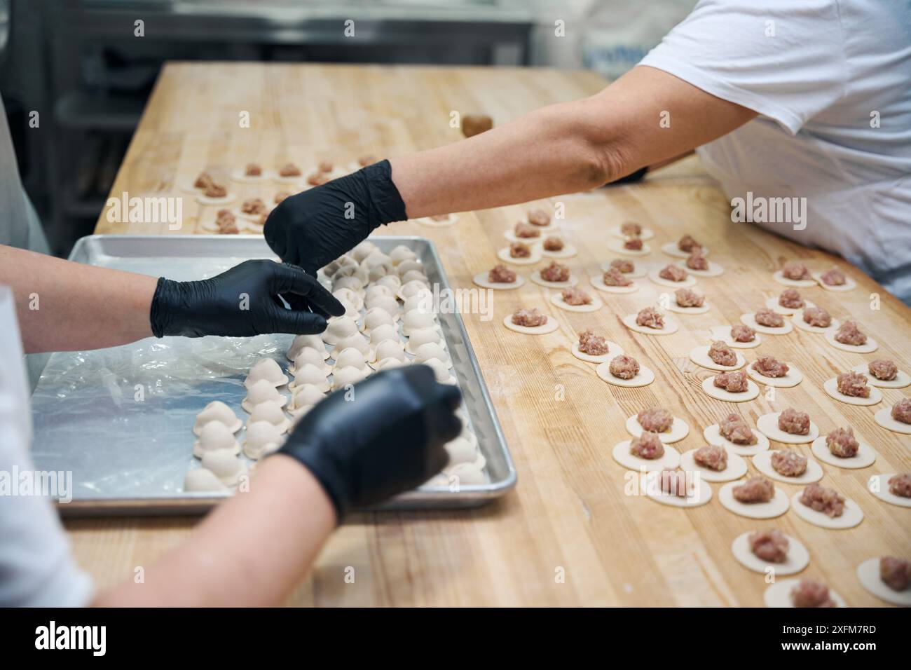 Kitchen employees make dumplings from minced meat and dough Stock Photo ...