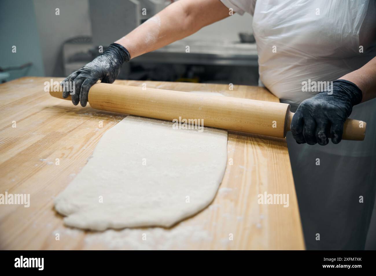 Experienced cook rolls out portion of dough with rolling pin Stock ...
