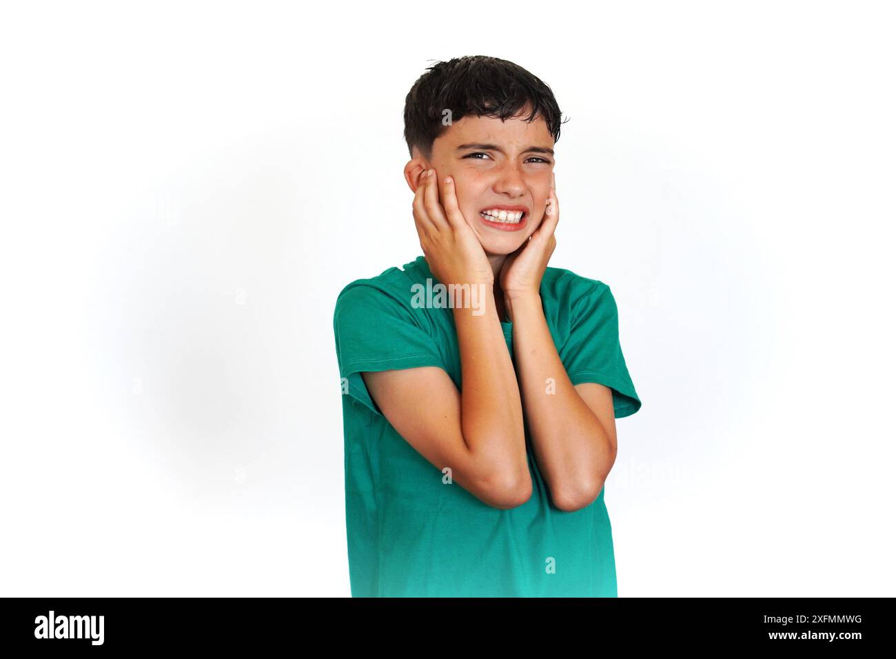 preadolescent child holding his fingers to his ears with a gesture of suffering and displeasure