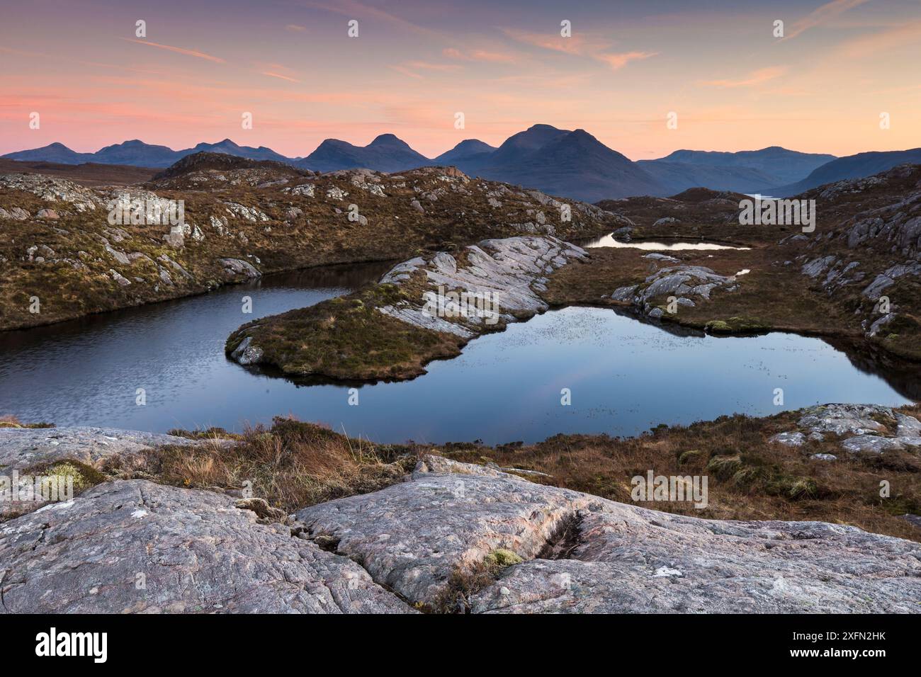 Sunset over remote hill lochan overlooking Loch Torridon to Ben Damph, Wester Ross, Scotland, UK, January Stock Photo