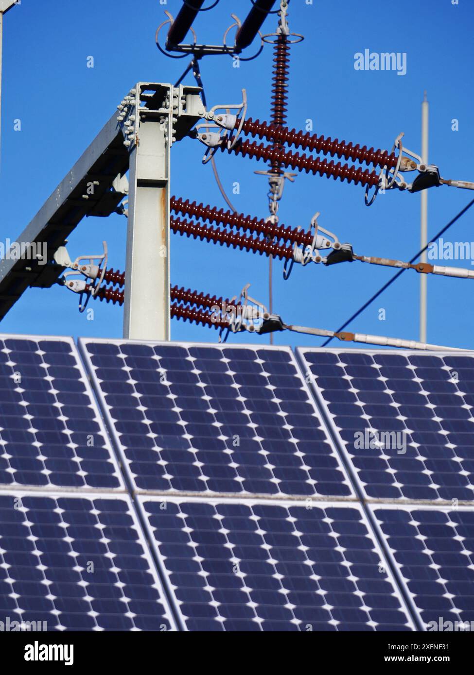 A solar panel is on top of a pole. The pole is connected to a power ...