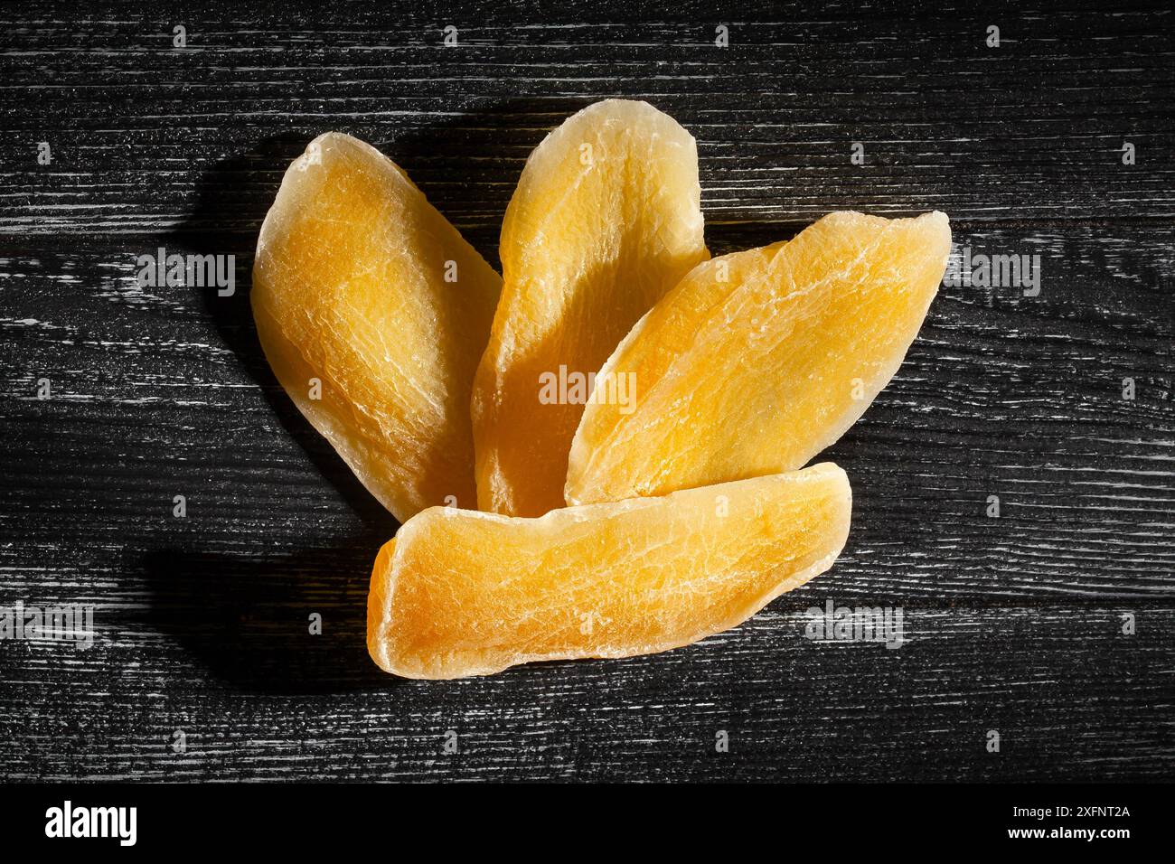 dried mango on black wood background top view Stock Photo