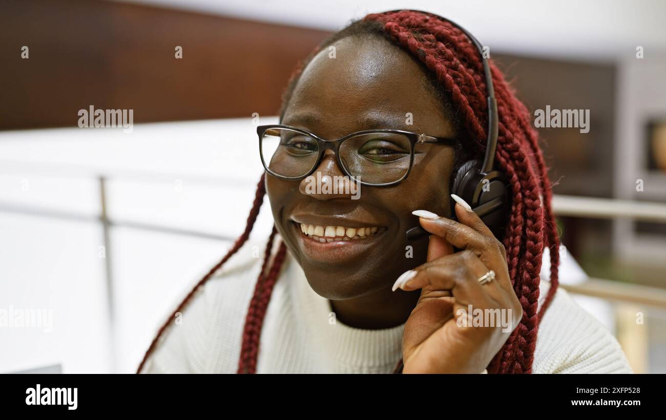 A smiling african american woman with braids wearing glasses and ...
