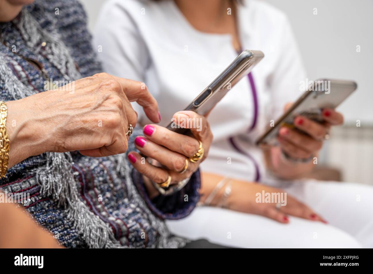 Nurse teaching elder woman how to use mobile phone senior grandmother