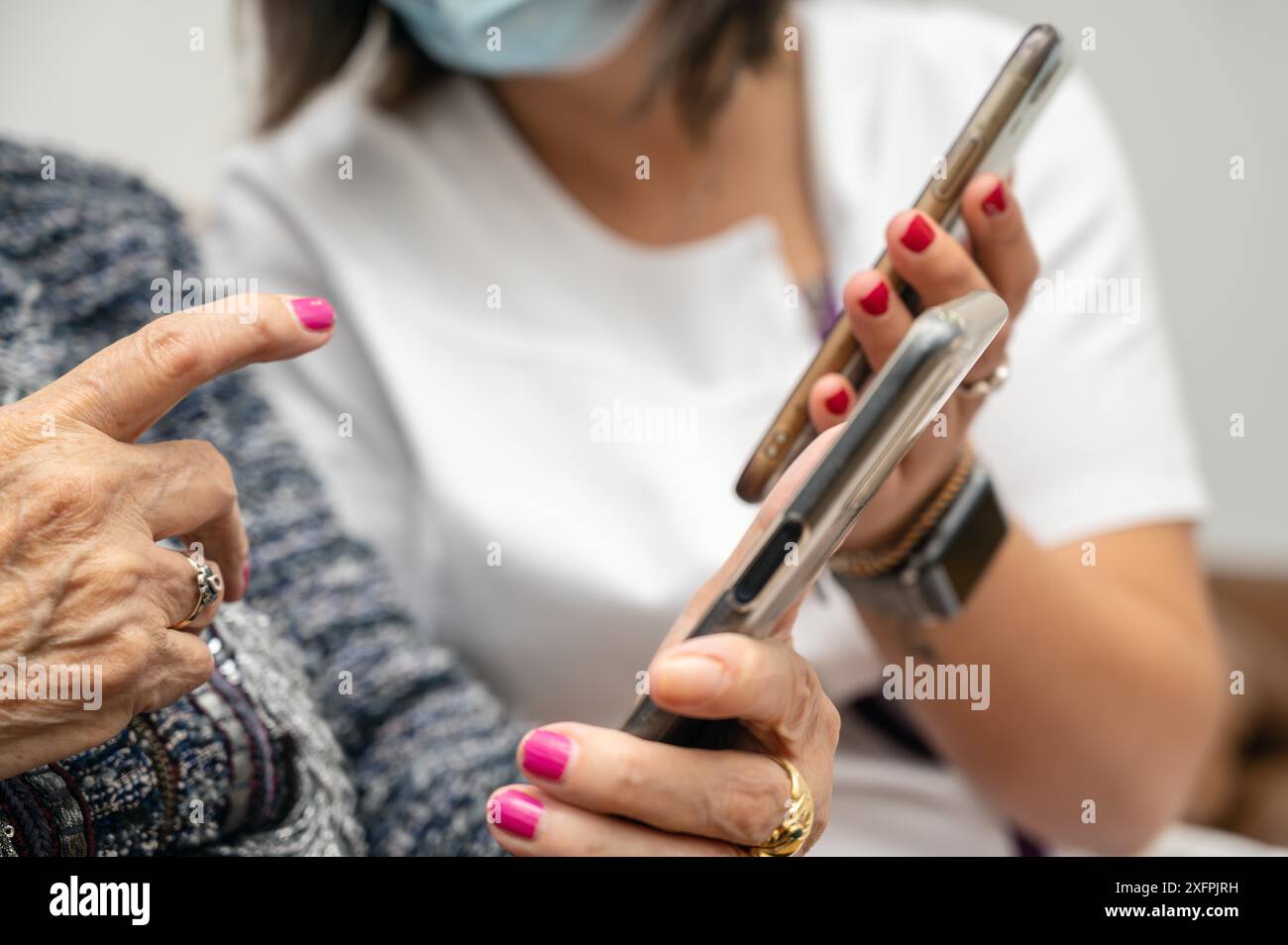 Nurse teaching elder woman how to use mobile phone senior grandmother