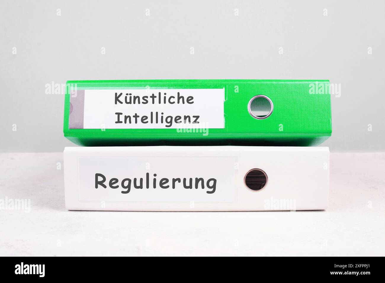 Folders with the words artificial intelligence and regulation, german language, AI technology in competition with human resource, manpower against Stock Photo