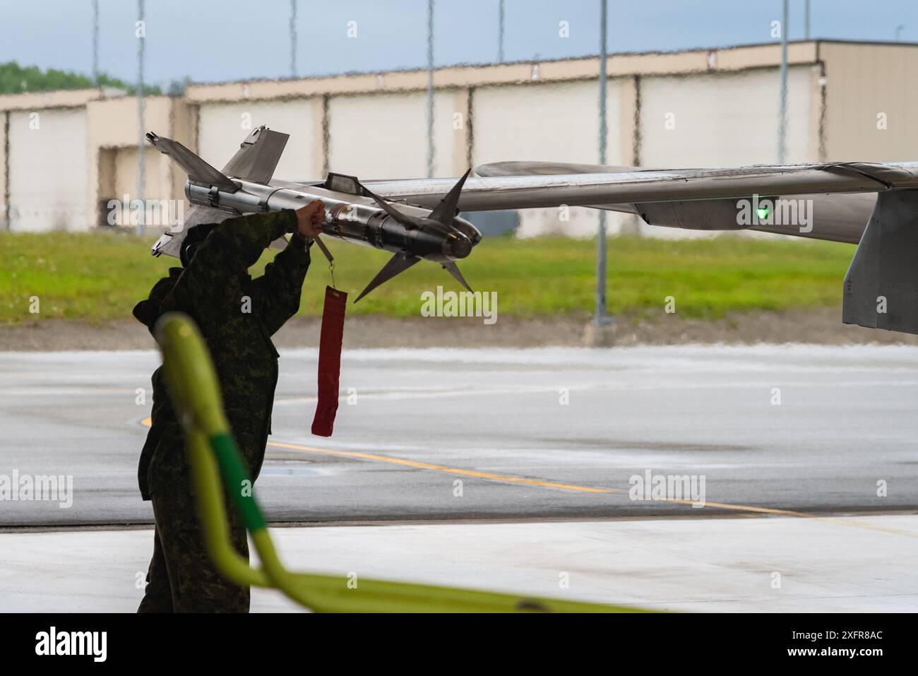 A North American Aerospace Defense Command CF-18 Hornet crew arms weapons prior to takeoff for a routine NORAD flight at Joint Base Elmendorf-Richardson, Alaska, June 12, 2024. NORAD ensures the homelands are defended from threats and adversary influence. Through strong partnerships, Canada and the United States ensures the national security of North America is maintained. (U.S. Air Force photo by Tech. Sgt. Don Hudson) Stock Photo